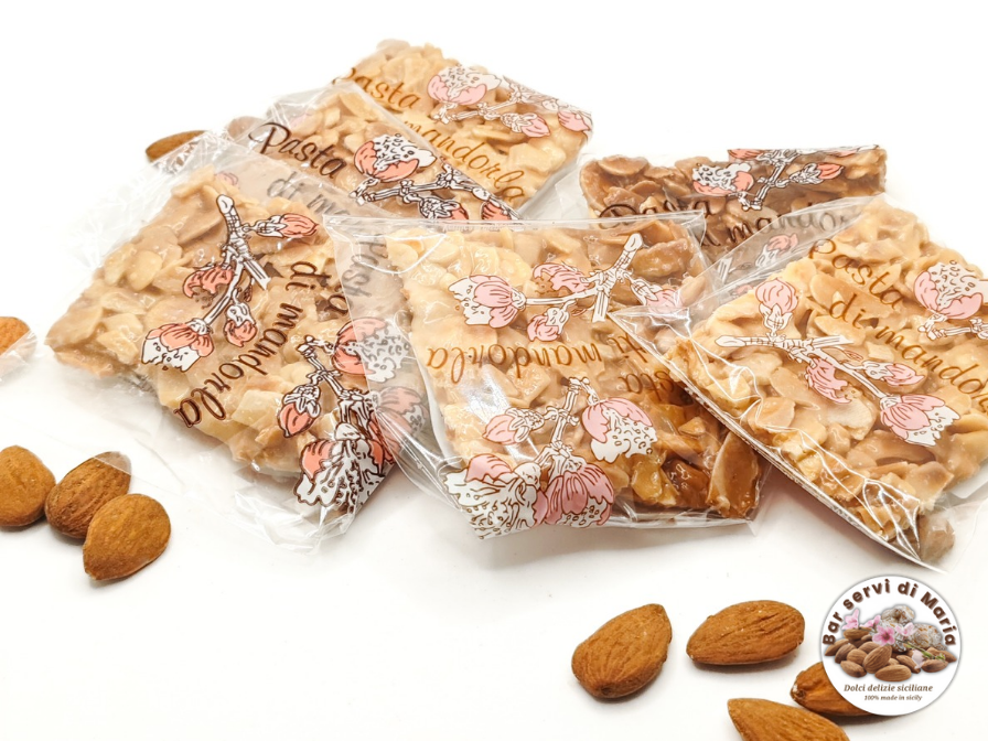 Torroncini sfoglia confezionati uno ad uno dolci delizie siciliane su sfondo bianco e mandorle su sfondo
